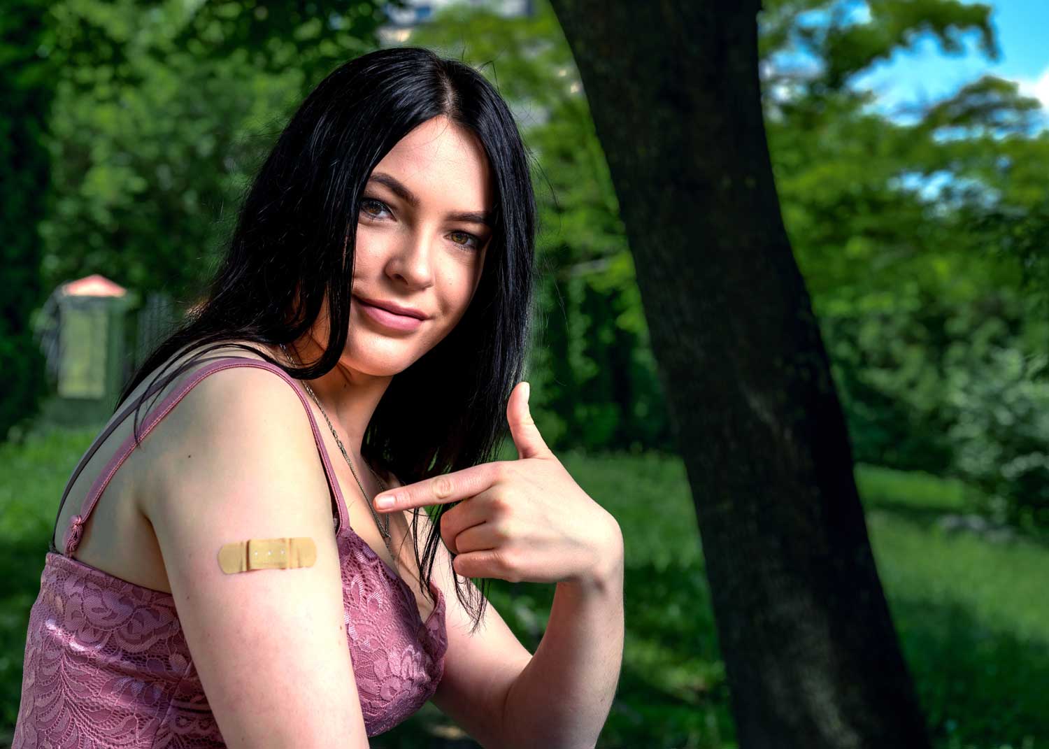 A woman sits on an exam table and talks to a nurse